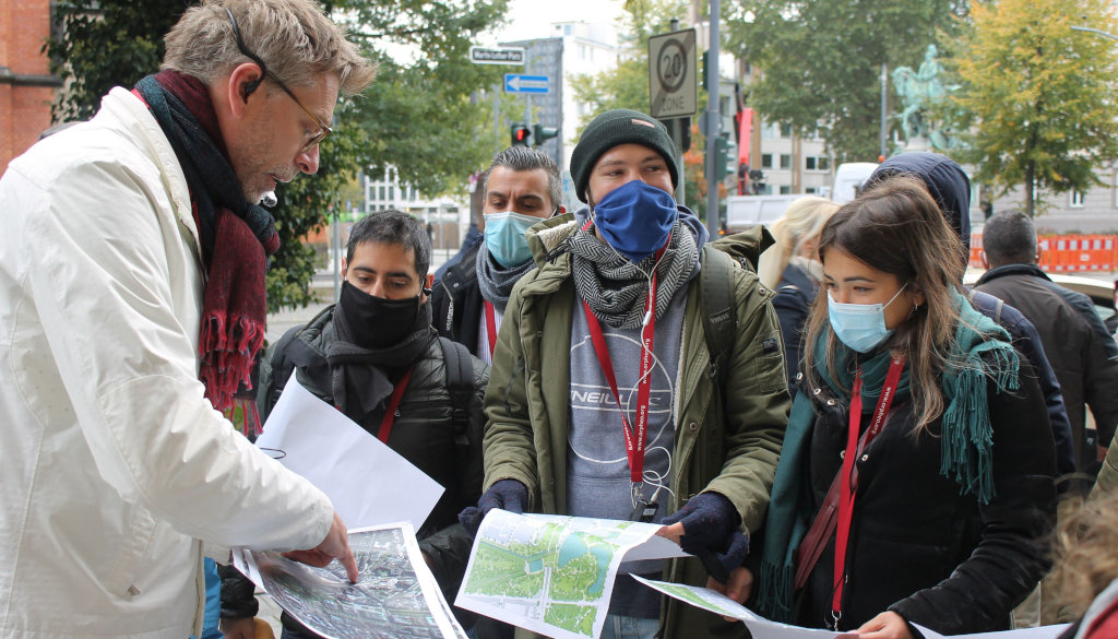 photo group of students with professor looking at plans