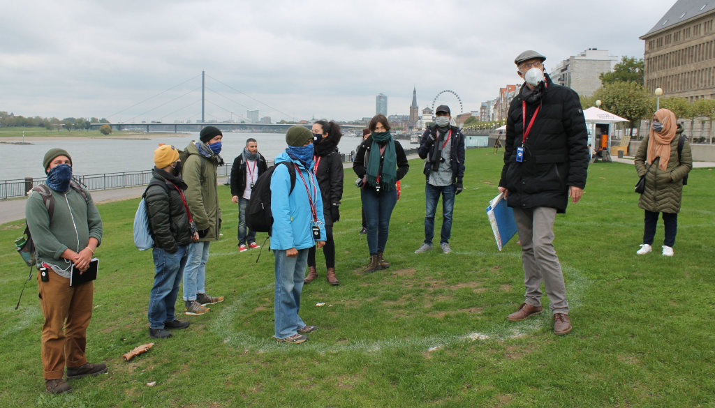 photo group of students with professor, on meadow with river in background