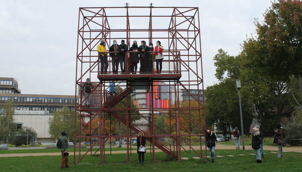 photo group of students with professor on, in front of and beside metal scaffolding